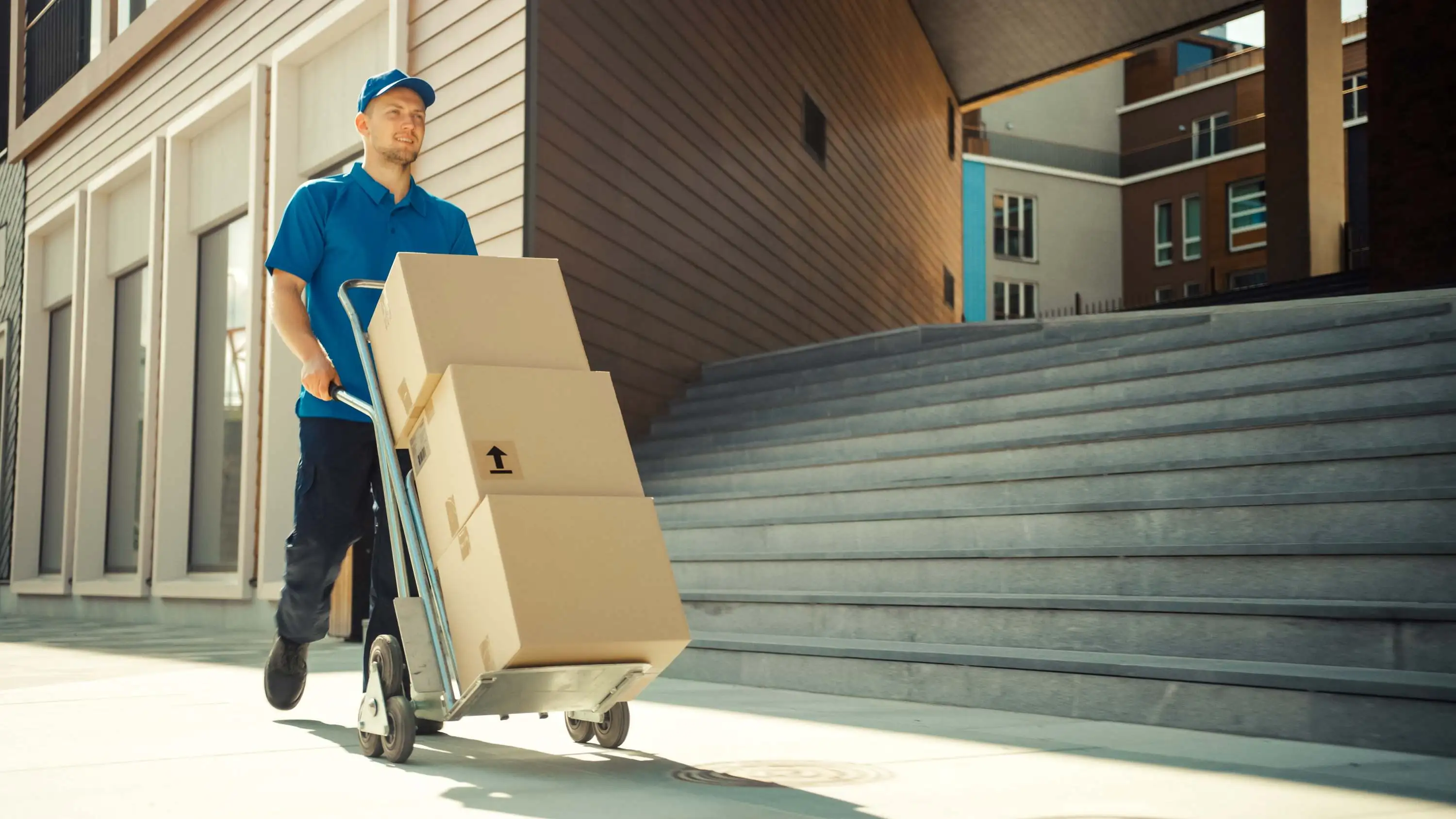 A courier transporting multiple parcels on a trolley